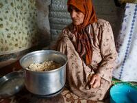 Umm Khaled cooks mushrooms in a pot in a camp in a town called Haarem in the northwestern province of Idlib on November 29, 2019. Aaref WATAD / AFP