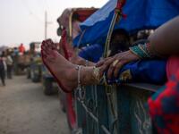 A devotee stretches her legs as she travels in a vehicle ahead of Gadhimai Festival in Baryarpur, 160 kms south of the Kathmandu, on December 2, 2019. Thousands of Hindu worshippers are flocking to a village in southern Nepal on December 2, defying court orders and calls by animal activists, in preparation for the world's biggest animal sacrifice. PRAKASH MATHEMA / AFP