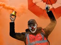 A man wearing the DC comic Joker character's mask and waving a smoke bomb takes part in a demonstration to protest against the pension overhauls, in Marseille, southern France, on December 5, 2019 as part of a national general strike. CLEMENT MAHOUDEAU / AFP