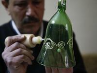 A Palestinian craftsman decorates a glass Christmas ornament at a workshop in the southern West Bank city of Hebron, on December 15, 2019. HAZEM BADER / AFP