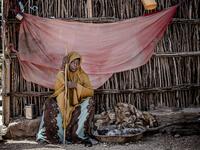 A displaced woman sits under the shadow at the place where she sleeps at a displacement camp in Beledweyne, Somalia, on December 14, 2019. The rains have inundated big areas surrounding Beledweyne area forcing thousands of people to leave their houses and look for humanitarian assistance while living in displacement camps. Due to climate change and human activities, cycles of floods and droughts have become more recurrent and completely unpredictable in Somalia exposing hundreds of thousands of people every