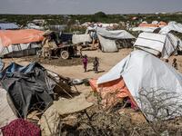 Two boys stand next to their tents at a displacement camp for people affected by intense flooding in Beledweyne, Somalia, on December 14, 2019. The rains have inundated big areas surrounding Beledweyne area forcing thousands of people to leave their houses and look for humanitarian assistance while living in displacement camps. Due to climate change and human activities, cycles of floods and droughts have become more recurrent and completely unpredictable in Somalia exposing hundreds of thousands of people 