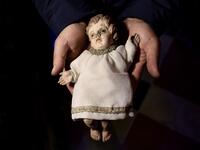 Volunteer Matteo Seia holds a nativity figure of Jesus, one of the most ancient figures of the 43rd edition of the "Presepio of Cavallermaggiore", a 300sqm Christmas Nativity crib in the Oratorio San Michele on December 20, 2019 in Cavallermaggiore, near Cuneo, Northwestern Italy. The "Presepio" is made by ten volunteers who every year spend 3 months to build a new edition with hundred of figures. MARCO BERTORELLO / AFP