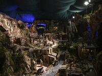 Volunteer Mario Curcetti walks through the "Presepio of Cavallermaggiore", a 300sqm Christmas Nativity crib in the Oratorio San Michele at its 43rd edition on December 20, 2019 in Cavallermaggiore, near Cuneo, Northwestern Italy. The "Presepio" is made by ten volunteers who every year spend 3 months to build a new edition with hundreds of figures. MARCO BERTORELLO / AFP