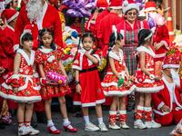 Children in Christmas costumes wait to receive gifts from elephants dressed in Santa Claus costumes during Christmas celebrations in Ayutthaya on December 23, 2019. Wearing red and white hats and a string of bells, Thai elephants passed out Christmas gifts to hundreds of schoolchildren on Monday despite growing criticism over using the animals in performances. The annual festive event is organised by a nearby elephant park, whose mahouts or handlers started in the early morning dressing the animals. Thailan