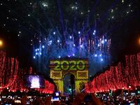 People take pictures of the fireworks erupting in the sky over the Arc de Triomphe during the New Year's celebrations on the Champs Elysees avenue, in Paris, on on January 1, 2020. Martin BUREAU / AFP