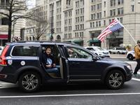 A man watches from a car as anti-war activist demonstrate outside the Trump International Hotel in Washington, DC, on January 4, 2020.ANDREW CABALLERO-REYNOLDS / AFP
