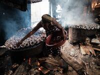 A picture taken on March 1, 2019 shows a woman smoking fish in the Makoko waterfront community in a polluted lagoon in Lagos, Africa’s biggest megalopolis in Nigeria. The sprawling community began in the 19th century as a fishing village for immigrants who settled on the water's edge. As more arrived and land became rare, people started to move out onto the water. Over time, Makoko became a floating realm of perhaps a quarter of a million people, although the real number is anyone's guess. YASUYOSHI CHIBA /
