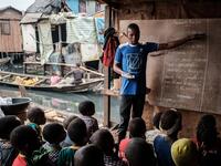 A picture taken on March 1, 2019 shows a teacher speaking to his students during his class at a private school in the Makoko waterfront community in a polluted lagoon in Lagos, Africa’s biggest megalopolis in Nigeria. The sprawling community began in the 19th century as a fishing village for immigrants who settled on the water's edge. As more arrived and land became rare, people started to move out onto the water. Over time, Makoko became a floating realm of perhaps a quarter of a million people, although t