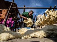 Mohamed Kamal, a 59-year-old dye worker, prepares to hang dyed yarns out to dry in the sun at a traditional hand-dying workshop in the Egyptian capital Cairo's centuries old district of Darb al-Ahmar on January 21, 2020. In Cairo's centuries-old Darb al-Ahmar district, Salama Mahmoud Salama's dye workshop is a multi-coloured den of textiles and busy workers colouring all kinds of fabrics. Khaled DESOUKI / AFP
