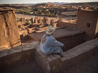 A man sits atop the Kasbah (ancient fortress) of Ait-Ben-Haddou, where scenes depicting the fictional city of Yunkai from the hit HBO television series "Game of Thrones" were filmed, about 32 kilometres northwest of the city of Ouarzazate south of Morocco's High Atlas mountains on January 27, 2020. FADEL SENNA / AFP