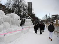 People visit the Sapporo Snow Festival in Sapporo on February 4, 2020. The snow festival, which opened January 31 in the capital of Hokkaido in northern Japan, is a major draw for the region, attracting more than 2.7 million visitors last year. Organisers for this year's festival were forced to truck in an unprecedented amount of extra powder to build their signature sculptures after an unseasonably warm winter.  CHARLY TRIBALLEAU / AFP