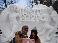 A couple poses for a selfie in front of a snow sculpture with a motif of the upcoming Tokyo 2020 Olympic Games, during the Sapporo Snow Festival in Sapporo on February 4, 2020. The snow festival, which opened January 31 in the capital of Hokkaido in northern Japan. CHARLY TRIBALLEAU / AFP