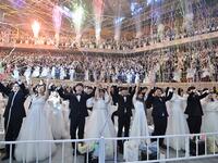 Couples cheer during a mass wedding ceremony organised by the Unification Church at Cheongshim Peace World Center in Gapyeong on February 7, 2020. Thousands of Unification Church couples married at a mass wedding to mark the eighth anniversary of the death of founder and self-proclaimed messiah Sun Myung Moon. Jung Yeon-je / AFP
