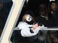 A masked reveller looks on aboard a ferry on the Grand Canal during the traditional regatta which officially opens the Carnival in Venice, on February 09, 2020. The Venice's carnival takes place until February 25, 2020. Vincenzo PINTO / AFP