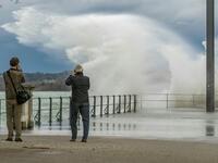 Two men take pictures of water spilling over a quay in the Eastern end of Lake Constance (Bodensee), as the storm Ciara reaches Austria, in Bregenz, Austria, on February 10, 2020. DIETMAR STIPLOVSEK / APA / AFP