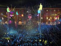 Giant figures depicting a king and a queen are seen through confetti rain during the 136th Nice Carnival parade in Nice, southeastern France, on February 15, 2020. The Carnival takes place until February 29, 2020 on the theme 'King of Fashion'. VALERY HACHE / AFP