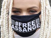 Nina from Amsterdam, a supporter of WikiLeaks founder Julian Assange, wears a face mask called for Assange's freedom as she poses for a photograph outside Woolwich Crown Court in southeast London on February 24, 2020, on the day of the opening of the full hearing into a US request for Assange's extradition. A British court on February 24 starts hearing Washington's extradition request for WikiLeaks founder Julian Assange in a test case of media freedoms in the digital age and the global limits of US justice