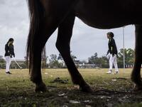 In this photograph taken on January 9, 2020, Linthoingambi Kangjei Lup Polo Club players Shanglenmayum Sangeeta (R) and Okram Ashalucky warm up before the start of their 15th Women's State Polo Tournament match at the Mapal Kangjeibung (Polo Ground) in Imphal, the capital of the northeastern Indian state of Manipur. Laishram Thadoi's face is a picture of concentration as she adjusts her helmet and prepares to play in Manipur, the remote Indian state regarded as the birthplace of modern polo. Xavier GALIANA 