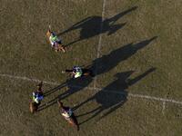 In this aerial photograph taken on January 11, 2020, Linthoingambi Kangjei Lup Polo Club players on their ponies gather on the field during a break of their 15th Women's State Polo Tournament match at the Mapal Kangjeibung (Polo Ground) in Imphal, the capital of the northeastern Indian state of Manipur. Laishram Thadoi's face is a picture of concentration as she adjusts her helmet and prepares to play in Manipur, the remote Indian state regarded as the birthplace of modern polo. Xavier GALIANA / AFP