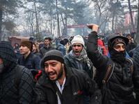 Migrants react as Greek anti-riot police officers use tears gas on the buffer zone Turkey-Greece border, at Pazarkule, in Edirne district, on February 29, 2020. Thousands of migrants stuck on the Turkey-Greece border clashed with Greek police on February 29, 2020. Ozan KOSE / AFP