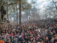 Migrants watch Greek police during clashes as they gather at the buffer zone Turkey-Greece border, at Pazarkule, in Edirne district, on February 29, 2020. Thousands of migrants stuck on the Turkey-Greece border clashed with Greek police on February 29, 2020, according to an AFP photographer at the scene. BULENT KILIC / AFP
