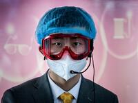 A worker at an information desk wearing protective gear as a preventive measure against the COVID-19 coronavirus looks on at a nearly empty arrivals area at Beijing Capital Airport in Beijing on March 16, 2020. China tightened quarantine measures for international arrivals as the country worries about a rise in imported cases of the deadly coronavirus and anger rages online at how Europe and the United States are handling the pandemic. NICOLAS ASFOURI / AFP