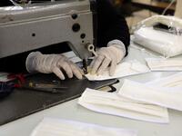 A Yemeni woman makes face masks at a textile factory in the capital Sanaa on March 16, 2020. More than a decade after it shut down, 20 women have brought back to life Yemen's oldest industrial factory to manufacture what could save many lives amid a global pandemic: masks. Mohammed HUWAIS / AFP
