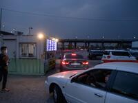 In a photo taken on March 21, 2020 customers queue in their cars to buy tickets at a drive-through cinema in Seoul. Box office numbers in South Korea -- which has 8,897 confirmed virus cases -- have plummeted in recent weeks due to the epidemic, with authorities urging the public to avoid large crowds. But at drive-in cinemas, moviegoers can enjoy a movie from the comfort of their cars, parked in front of a large outdoor screen.  Ed JONES / AFP