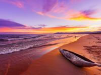 Lake Malawi sunset in Kande beach Africa, canoe boat on beach peaceful beach holiday beautiful sunset colors blue purple orange yellow in sky and clouds (Shutterstock)