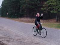 An elderly woman on her bicycle waves on November 20, 2019 on Kihnu island in the Baltic Sea, 10 kilometres (six miles) off the coast of Estonia. Steeped in folk traditions, Kihnu's historic way of life however is now threatened as economic hardship drives more and more islanders away in search of work. Alessandro RAMPAZZO / AFP