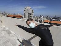 Sherazade Mami, a 28-year-old Tunisian professional dancer and performer at the Caracalla dance theatre and a teacher at the Caracalla dance school, practices while wearing a surgical mask on the roof of her apartment building in the suburb of Dekwaneh on the eastern outskirts of Lebanon's capital Beirut on April 4, 2020. Due to the confinement regulations imposed to combat the COVID-19 coronavirus pandemic, Mami opted to continue practicing on her rooftop to remain in shape. JOSEPH EID / AFP