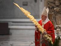 Pope Francis holds a palm branch as he celebrates Palm Sunday mass behind closed doors at St. Peter's Basilica mass on April 5, 2020 in The Vatican, during the lockdown aimed at curbing the spread of the COVID-19 infection, caused by the novel coronavirus. Alberto PIZZOLI / POOL / AFP