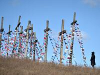 A man stands in front of giant crosses on April 5, 2020 in the town of Achmiany, some 130 km northwest of Minsk, during Palm Sunday celebrations which mark a week before Easter. Sergei GAPON / AFP