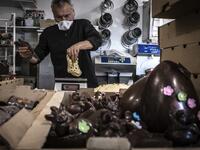 An employee of pastry and chocolate maker Didier Girard prepares Easter chocolate before delivering them at clients' homes in Vourles, near Lyon at on April 7, 2020, on the twenty-second day of a strict lockdown in France to stop the spread of COVID-19, caused by the novel coronavirus. JEAN-PHILIPPE KSIAZEK / AFP