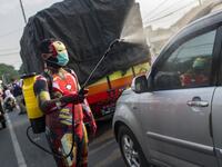 An Indonesian police officer wearing a superhero costume on the street disinfects motorists' vehicles in Pasuruan, East Java on April 9, 2020, amid concert to the COVID-19 coronavirus. JUNI KRISWANTO / AFP