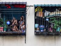Residents watch from their flats' windows a music band formed by Sri Lankan Navy personnel as they play outside a housing complex during a government-imposed nationwide lockdown as a preventive measure against the COVID-19 coronavirus, in Colombo on April 9, 2020. ISHARA S. KODIKARA / AFP