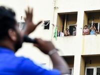 Residents watch from their flats' windows a music band formed by Sri Lankan Navy personnel as they play outside a housing complex during a government-imposed nationwide lockdown as a preventive measure against the COVID-19 coronavirus, in Colombo on April 9, 2020. ISHARA S. KODIKARA / AFP