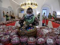 An Orthodox volunteer inspects traditional cakes and eggs before of blessing to be distributed to people in need, on the eve of the Orthodox Easter in Moscow on April 18, 2020, during a strict lockdown in Russia to stop the spread of COVID-19, caused by the novel coronavirus. All church in Moscow were closed to believers and remained open only for priests and personal. Kirill KUDRYAVTSEV / AFP