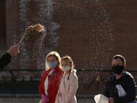 A priest of the Greek Catholic Church blesses believers wearing face masks as they keep social distance during the celebration of Orthodox Easter outside the Church of the Nativity of the Blessed Virgin, in western Ukrainian city of Lviv, on April 18, 2020, amid the COVID-19 pandemic caused by the novel coronavirus. Yuri DYACHYSHYN / AFP