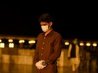 A Muslim wearing facemask and gloves offers a special 'Taraweeh' evening prayer ahead of the first day of the Muslim holy month of Ramadan at the Grand Faisal Mosque in Islamabad on April 24, 2020.  Aamir QURESHI / AFP