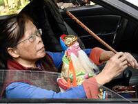 In this picture taken on March 17, 2020, a woman takes her new Taoist god statue home after it was restored by sculptor Lin Hsin-lai at his workplace in Taoyuan, northern Taiwan. Every spare surface of Lin Hsin-lai's four-storey shop is crammed with a pantheon of Taiwan's celestial beings, testament to the decades he has spent sheltering and restoring unwanted statues of gods.  Sam Yeh / AFP