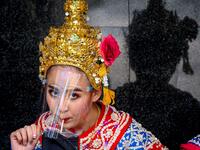 A traditional Thai dancer drinks under her protective face shield before a performance at the Erawan Shrine, which was reopened after the Thai government relaxed measures to combat the spread of the COVID-19 novel coronavirus, in Bangkok on May 4, 2020. Thailand began easing restrictions related to the COVID-19 novel coronavirus on May 3 by allowing various businesses to reopen, but warned that the stricter measures would be re-imposed should cases increase again. Mladen ANTONOV / AFP