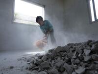 A Syrian youth whose family decided to return home for fear of the COVID-19 pandemic in packed camps for the internally displaced, cleans the rubble from a room in his house in al-Nayrab, a village ravaged by pro-government forces bombardment near the M4 strategic highway, in Syria's northwestern Idlib province, on May 3, 2020. Bakr ALKASEM / AFP