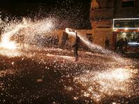 A Palestinian youth swings a homemade sparkler firework as people celebrate on a night of the Muslim holy month of Ramadan in Rafah refugee camp, in the southern Gaza Strip, on May 4, 2020. MAHMUD HAMS / AFP