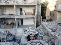 This picture taken on May 4, 2020 during the Muslim holy fasting month of Ramadan shows members of the displaced Syrian family of Tareq Abu Ziad, from the town of Ariha in the southern countryside of the Idlib province, breaking their fast together for the sunset "iftar" meal, in the midst of the rubble of their destroyed home upon their return to the town for one day after fleeing during the previous military assault by Syrian government forces and their allies. AAREF WATAD / AFP