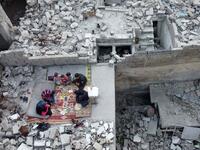 This picture taken on May 4, 2020 during the Muslim holy fasting month of Ramadan shows an aerial view of members of the displaced Syrian family of Tareq Abu Ziad, from the town of Ariha in the southern countryside of the Idlib province, breaking their fast together for the sunset "iftar" meal, in the midst of the rubble of their destroyed home upon their return to the town for one day after fleeing during the previous military assault by Syrian government forces and their allies. Aaref WATAD / AFP
