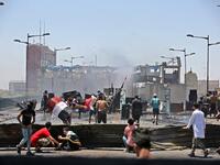 Iraqi protesters take cover as they clash with security forces during an anti-government demonstration on Al-Jumhuriyah bridge in the capital Baghdad, on May 10,2020. Modest anti-government rallies resumed in some Iraqi cities today, clashing with security forces and ending months of relative calm just days after Prime Minister Mustafa Kadhemi's government came to power. AHMAD AL-RUBAYE / AFP