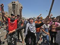 A woman shouts slogans as she takes part with Iraqi protesters in an an anti-government demonstration on Al-Jumhuriyah bridge in the capital Baghdad, on May 10,2020. Modest anti-government rallies resumed in some Iraqi cities today, clashing with security forces and ending months of relative calm just days after Prime Minister Mustafa Kadhemi's government came to power. AHMAD AL-RUBAYE / AFP