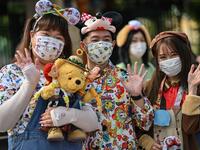 People wearing face masks wait to enter the Disneyland amusement park in Shanghai on May 11, 2020. Disneyland Shanghai reopened on May 11 to the public after being closed since January due to the COVID-19 coronavirus outbreak. Hector RETAMAL / AFP